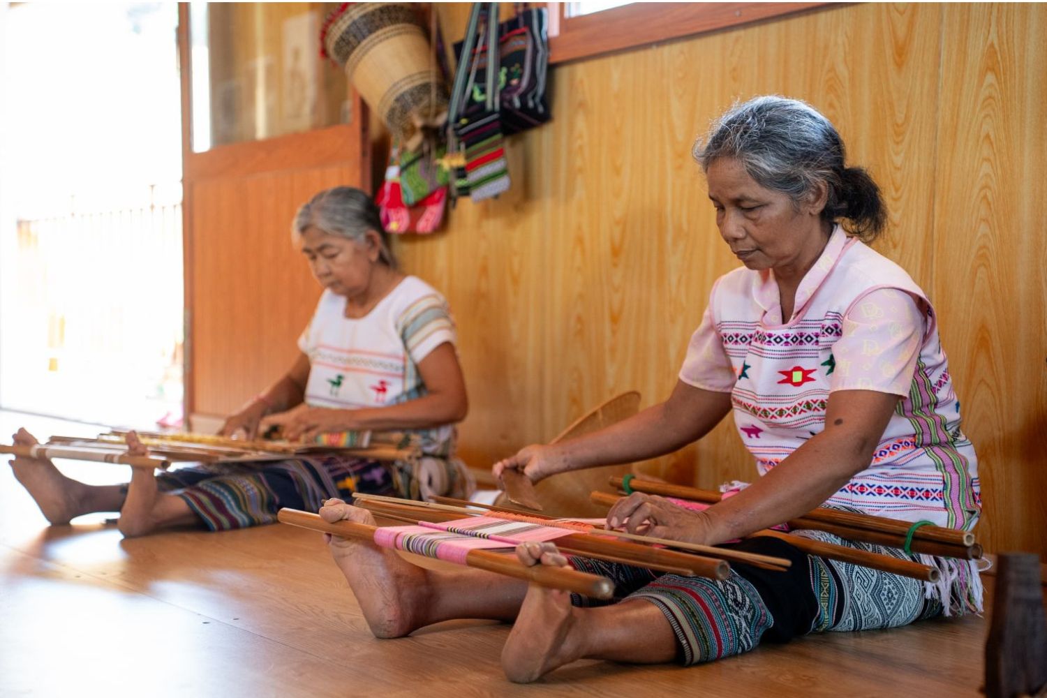 Many artisans are weaving fabric to make traditional clothing.